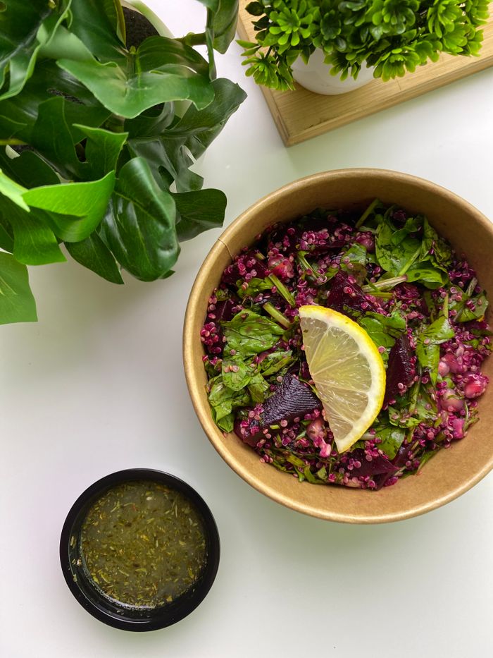 Vibrant beetroot salad with fresh greens and a lemon slice, perfect for a healthy meal.
